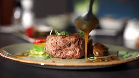 A chef finishing a plated dish